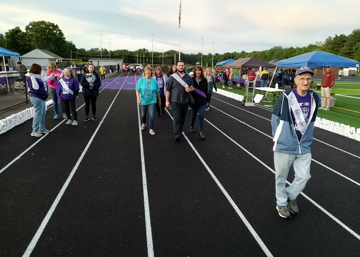 Survivors and their caregivers walk the track during the opening lap of the Relay For Life of Greater Attleboro.
